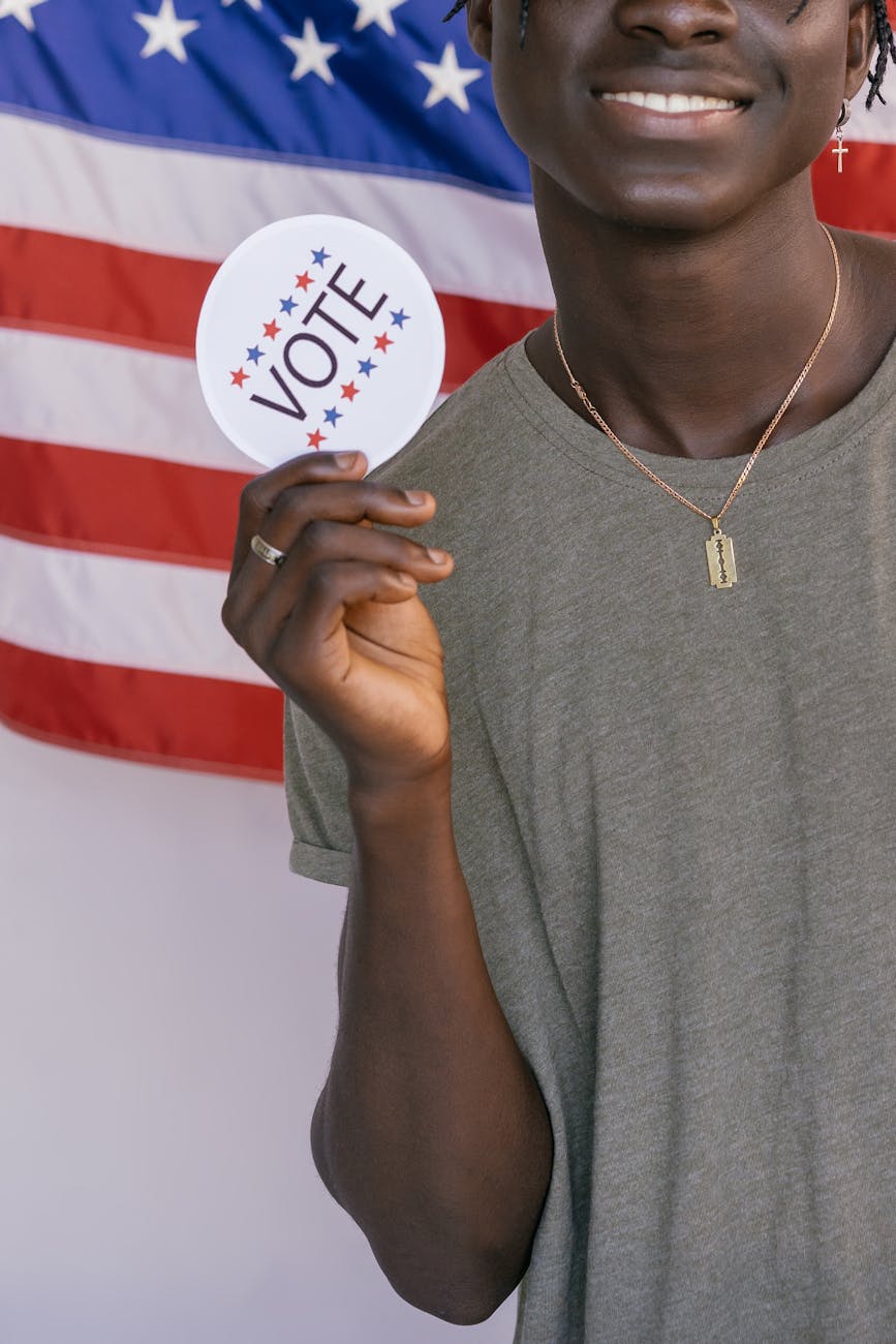 man holding vote badge